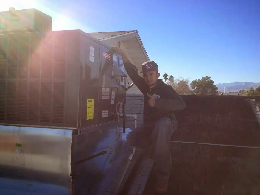 HVAC technician performing Air Duct Cleaning on a rooftop unit in Gulf Park Estates